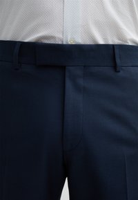 Dunkelblaue, maßgeschneiderte Hosen aus strukturiertem Stoff mit flachem Frontdesign, Gürtelschlaufen und einem glatten Taillendesign.