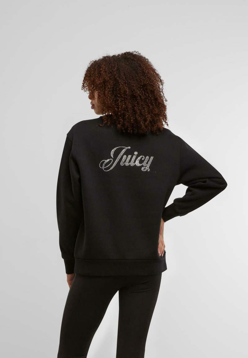 Črna dukserica z napisom "Juicy" v rhinestones na hrbtni strani. Ima ohlapen kroj, dolge rokave ter rebrast rob in manšete.