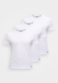 Τρία απλά λευκά βαμβακερά t-shirts με κοντά μανίκια και λαιμόκοψη στρογγυλή, με διακριτική σήμανση στο στρίφωμα.