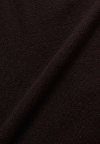 Dunkelbrauner Stoff mit einer weichen Textur und einem subtilen Strickmuster, leicht drapiert, um seine glatte Oberfläche und Tiefe zu offenbaren.