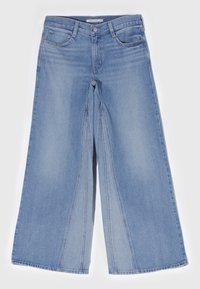 Jeans de pierna ancha en denim azul claro, con costuras en la parte delantera, cremallera y cinco bolsillos. Textura suave con un diseño informal.