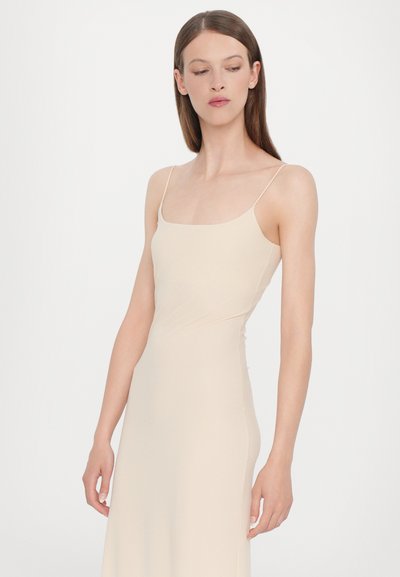 Heledbeez toppeta kleit õhukeste rihmadega, liibuv torso ja voolav seelik. Sile tekstuur, minimalism ja ruudukujuline kaelus.