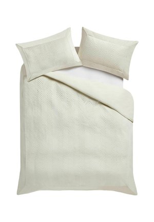 Couvre-lit couleur crème et deux taies d'oreiller assorties avec un motif matelassé en chevrons subtil sur fond blanc.
