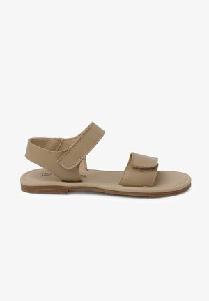 Sandal en cuir tan avec deux sangles à boucle auto-agrippante, semelle plate et design minimaliste. La semelle intérieure est rembourrée pour un confort supplémentaire.