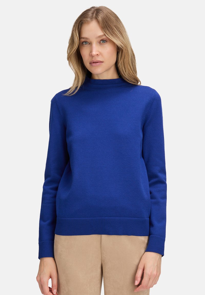 Blå jumper med hög krage, långa ärmar och ribbade manschetter. Tillverkad av ett mjukt stickat tyg med en bekväm passform.