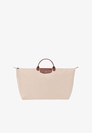 Beige nylon tote bag with a rounded brown leather handle, gold hardware, and a subtle front pocket. Features a zip closure at the top.