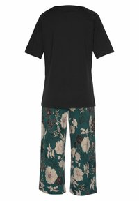 Black cotton T-shirt with short sleeves paired with teal floral patterned pants featuring large cream and dark floral designs.