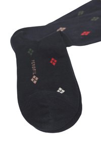 Calze nere con un motivo di piccoli quadrati colorati in rosso, verde, beige e bianco. Realizzate in un tessuto morbido con una texture a coste.