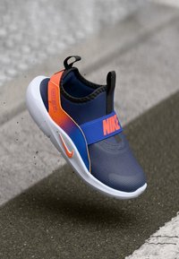 Blau-orange Nike Slipper mit strukturiertem Obermaterial, abgerundeter Zehenpartie und elastischem Riemen. Weiße Sohle mit markanten Logodetails.