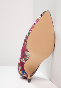 Tacco a punta in tessuto bordeaux con ricami floreali multicolori. Presenta una silhouette elegante e una suola liscia di colore chiaro.