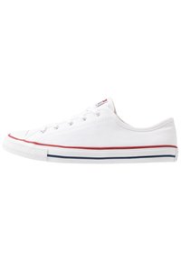 Vita låga canvas sneakers med röda och blå ränder på gummisulan, vita snören och metalldetaljer, sedd från utsidan.