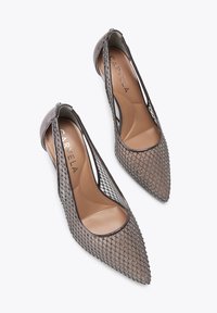 Scarpe con punta affusolata e tomaia in rete con accenti argentati, lati aperti e un interno beige liscio. Il colore è un grigio tenue.