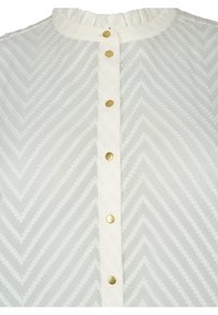 Bílá košile s volánovým límečkem, vzorem rybí kost a zlatými druky po celé přední straně. Strukturální látka.