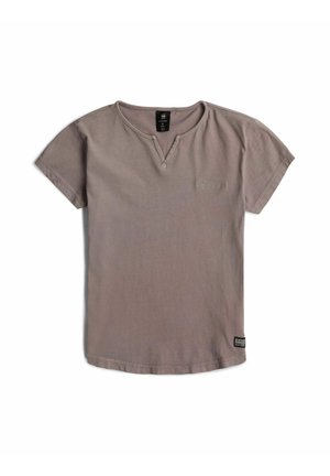 Graues T-Shirt mit kurzen Ärmeln, kleinem V-Ausschnitt am Kragen, dezentem Brustlogo und einem schwarzen Markenetikett nahe dem unteren Saum auf der rechten Seite.