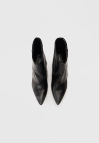 Black leather ankle boots with pointed toes, positioned side by side, viewed from above on a white background.