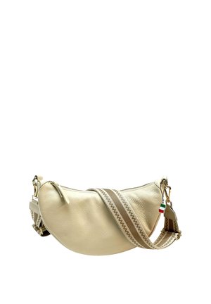 Sac en cuir crème porté croisé avec une silhouette courbée. Équipé d'une sangle réglable à rayures et d'un petit détail de drapeau. Accents en métal doré.