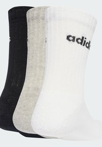Trzy pary bawełnianych skarpetek typu crew w kolorach czarnym, szarym i białym. Każda z nich ma prążkowaną strukturę oraz czarne logo "adidas".