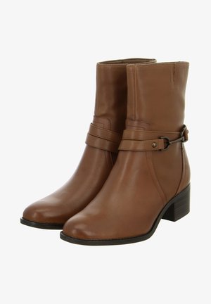 Brown leather ankle boots with a rounded toe, a low stacked heel, and a decorative strap with a metal accent around the ankle.