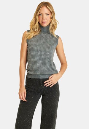 Top sin mangas de color gris con un patrón texturizado y dobladillo acanalado, combinado con pantalones negros que tienen detalles en forma de puntos.