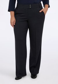 Pantalones de traje gris oscuro con una textura suave, que cuentan con dos bolsillos frontales y dos botones decorativos en la cintura.