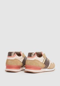 Baskets en daim marron et beige avec accents métalliques, détails roses et un design texturé au niveau du talon. Fermeture velcro pour un enfilage facile.