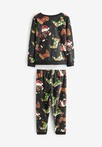 Barnens pyjamas-set med en svart bakgrund och färgglada tryck av pepparkakor, jultomtedräkter och festliga motiv. Mjukt tyg.