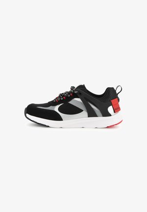 Basket de sport noire, grise et blanche avec des accents rouges, en mesh et en suède, avec une languette de talon brandée sur fond blanc.