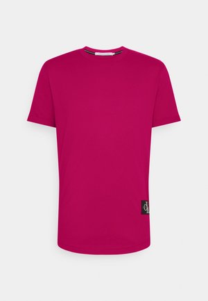 T-shirt in cotone magenta con scollatura rotonda, maniche corte e toppa con logo sul lato. Tessuto liscio e vestibilità classica.