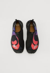 Crne slip-on cipele s mrežastim gornjištem koje ima apstraktni dizajn u ljubičastoj i crvenoj boji, teksturiranom uloškom i fleksibilnom gumom. Lagan dizajn.