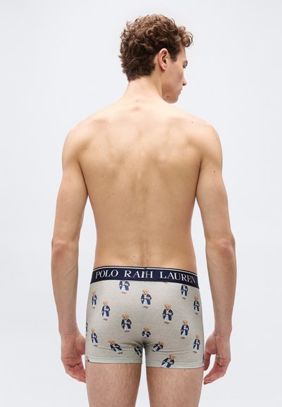 Άνδρας που φαίνεται από πίσω, φοράει ανοιχτό γκρι εσώρουχα τύπου μποξέρ με τυπωμένες αρκουδάκια και μπλε σκούρα μέση με το λογότυπο "Polo Ralph Lauren".