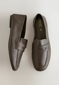 Rudi odos, paslydami loaferiai su siuvinėtomis detalėmis, plokščiomis juodomis padangomis ir "NEXT Forever Comfort" etikete viduje.