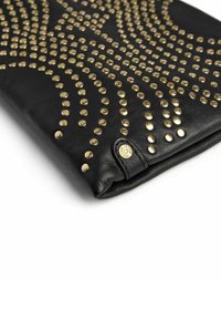 Čierna kožená kabelka do ruky so zlatými cvočkami usporiadanými do špirálového vzoru. Obsahuje malý logotyp na klopni.