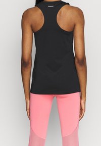 Czarny bezrękawnik z okrągłym dekoltem, gładka tekstura. W zestawie z różowymi legginsami z kolorowym blokowaniem i akcentami z siateczki.