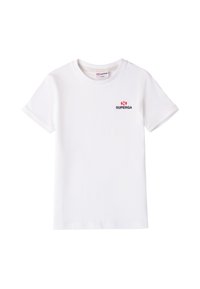 Camiseta de algodón blanca con mangas cortas, cuello redondo y un pequeño logotipo "SUPERGA" en negro y rojo en el lado izquierdo del pecho. Textura suave.