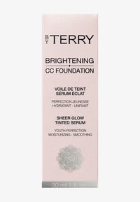 Emballage en boîte rose pour le Fond de teint CC Éclaircissant By Terry, avec du texte noir et une icône de fleur. Contient 30 ml de sérum teinté.