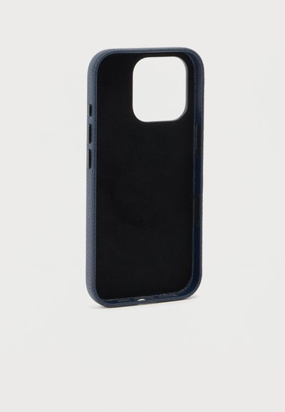 Λεπτή σκοτεινή μπλε δερμάτινη θήκη τηλεφώνου με ανοίγματα για την κάμερα και τα κουμπιά, παρουσιάζεται σε όρθια θέση σε λευκό φόντο.