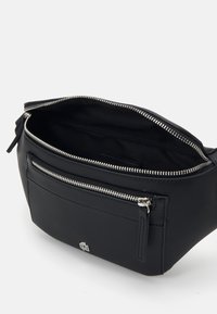 Sac banane synthétique noir avec un compartiment principal zippé et une poche avant. Présente des accessoires en métal argenté et une texture lisse.