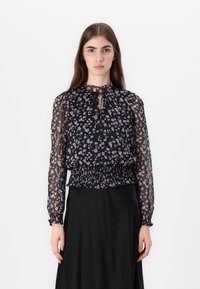 Blusa nera a fiori con maniche lunghe in trasparenza, vita arricciata e scollo a chiave. Presenta piccoli motivi floreali rosa e blu.