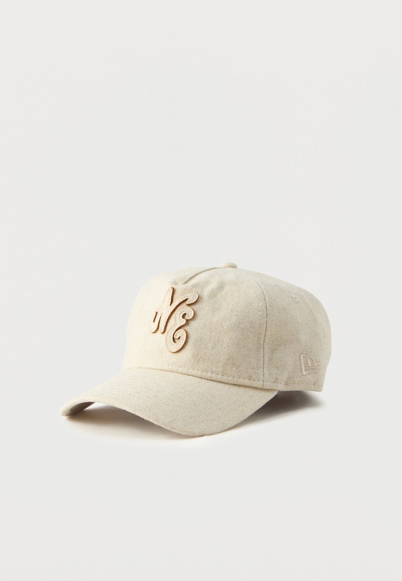Beige cap made of soft fabric featuring a curved brim, embroidered "NE" logo in light tan, and a small logo tag on the side.