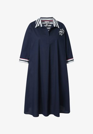 Marineblå knælængde kjole med trekvartlange ærmer, hvidstribet krave og manchetter samt en matchende stribet stofblomst på brystet.