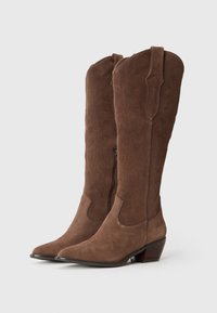 Brown suede cowboy boots with pointed toes, decorative stitching, and a side zipper. The design includes curved accents and a stacked heel.