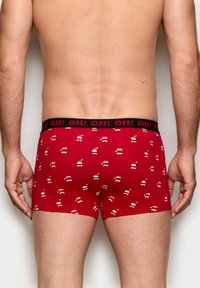 Rote Baumwoll-Boxershorts mit schwarzem Bund, versehen mit einem wiederholten Muster aus weißen Weihnachtsmützen und Schnurrbärten. Enganliegendes Design.