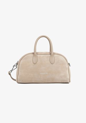 Beige suede handbag with rounded top, two handles, detachable shoulder strap, and subtle silver logo on front center.