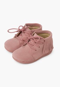 Botines de ante rosa con cordones y detalles de flecos en la parte trasera. Textura suave y forma de punta redonda; suelas de goma planas.