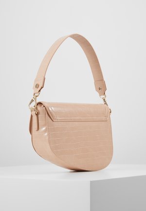 Beige skuldertaske i imiteret krokodillelæder med klaplukning og bred aftagelig rem, vist på en hvid piedestal.