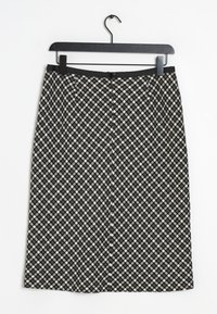 Knielange zwart en crème rok met een ruitpatroon, voorzien van een ritssluiting en een gladde tailleband, hangend aan een zwarte hanger.