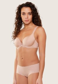 Sujetador rosa claro con detalles de encaje y tirantes ajustables; tela suave con copas moldeadas. Combinado con braguitas sin costuras a juego en rosa claro.