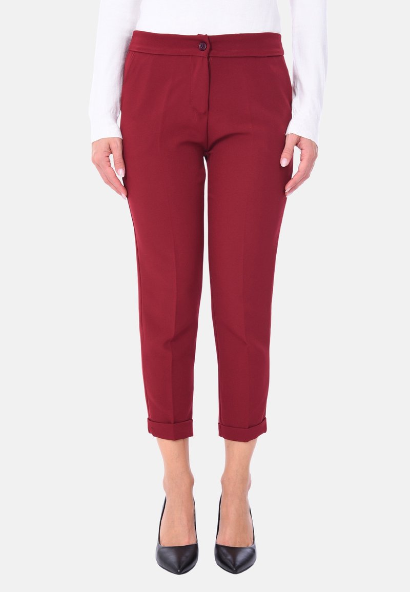 Pantaloni tagliati bordeaux con una consistenza liscia, dotati di chiusura a bottone e orli arrotolati, abbinati a tacchi a punta neri.