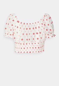 Blusa bianca corta con maniche a palloncino, decorata con motivi floreali rossi e rosa e un orlo inferiore arricciato.