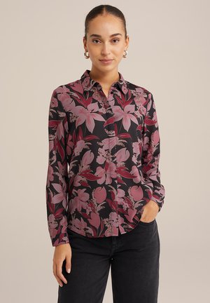 Long-sleeve button-up shirt featuring a black fabric with pink and burgundy floral patterns. Designed with a collared neckline and curved hem.